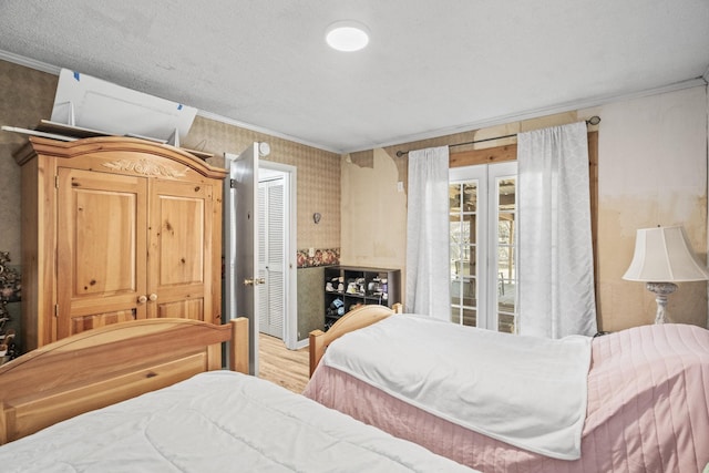 bedroom with ornamental molding and wood finished floors