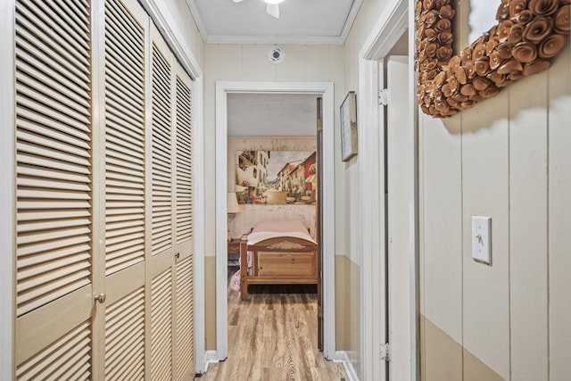 hall featuring light wood finished floors and ornamental molding