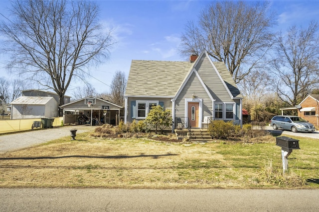 view of front of house featuring driveway, a chimney, and a front yard