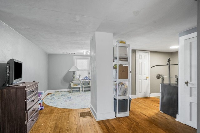interior space with visible vents, light wood-style flooring, and baseboards