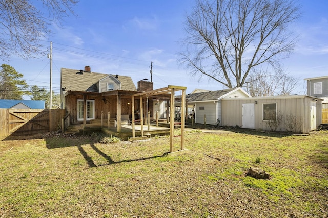 rear view of property with a patio, fence, a lawn, a gate, and a chimney