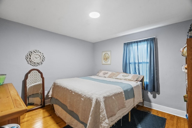 bedroom with baseboards and wood finished floors