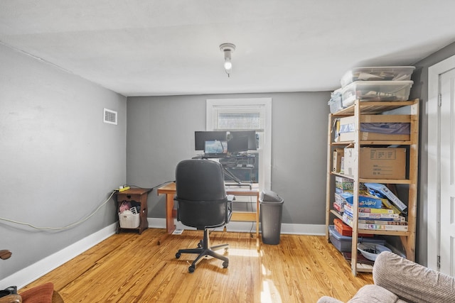 office with visible vents, baseboards, and wood finished floors