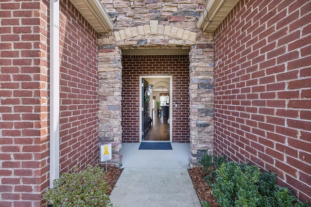 property entrance featuring stone siding and brick siding