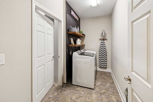 laundry room with laundry area, baseboards, and washer and dryer