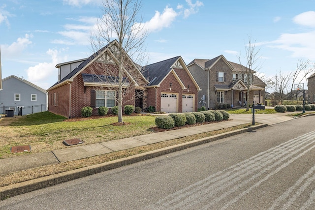 view of front of house featuring a garage, brick siding, a residential view, central air condition unit, and a front yard