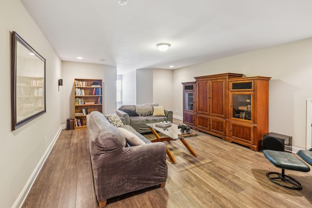 living area featuring baseboards, wood finished floors, and recessed lighting