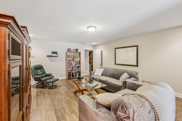 living area featuring light wood finished floors, baseboards, and recessed lighting