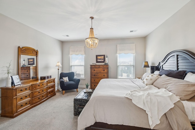 bedroom featuring light carpet, visible vents, and a notable chandelier