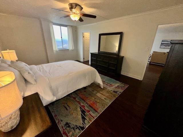 bedroom featuring baseboards, dark wood finished floors, a ceiling fan, and crown molding