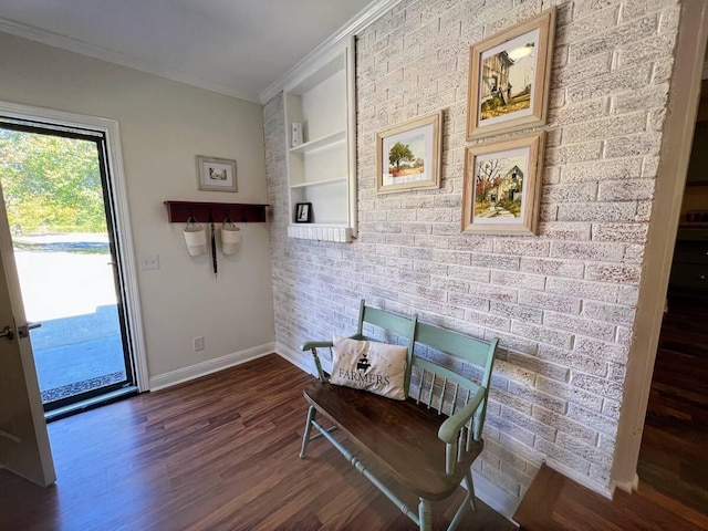 sitting room with baseboards, brick wall, ornamental molding, dark wood-style flooring, and built in shelves