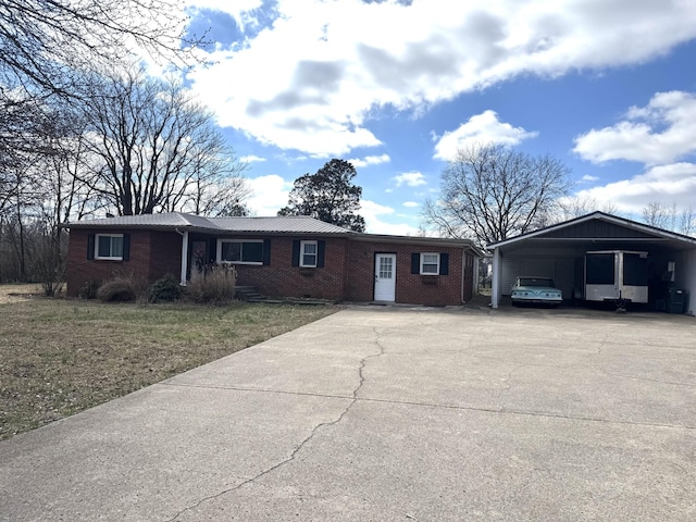 ranch-style home featuring brick siding, driveway, a front yard, and a carport