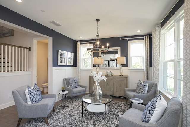 sitting room with visible vents, baseboards, wainscoting, dark wood-style floors, and a chandelier