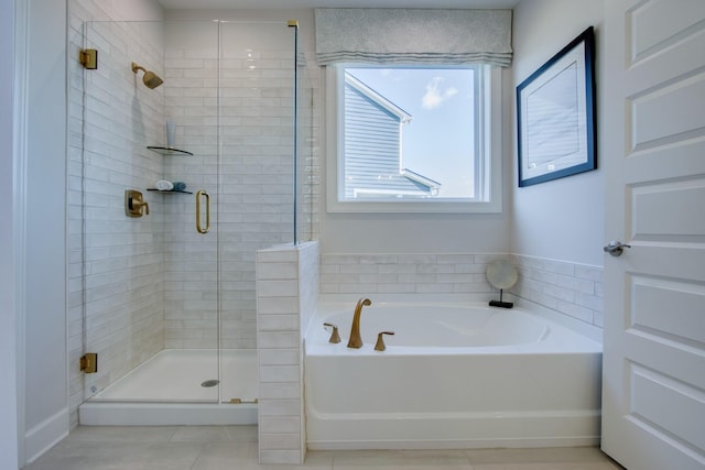 bathroom with a garden tub, a shower stall, and tile patterned floors