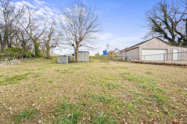 view of yard featuring a garage, an outdoor structure, a storage unit, and fence