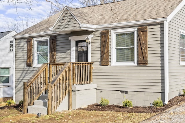 doorway to property featuring a shingled roof and crawl space