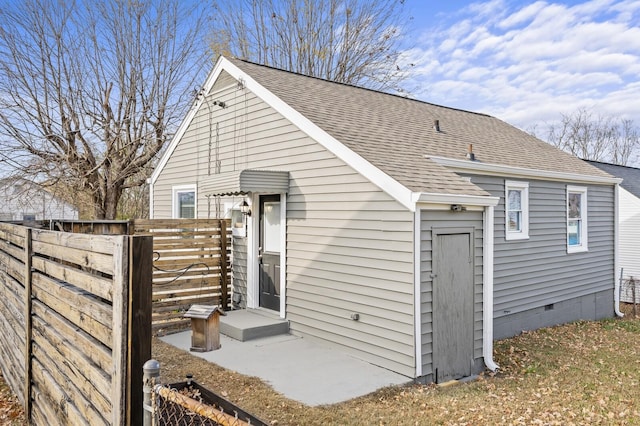 back of property with crawl space and a shingled roof