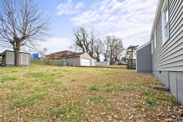 view of yard featuring fence, an outdoor structure, and a shed