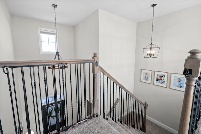 stairs featuring baseboards, a notable chandelier, and carpet flooring