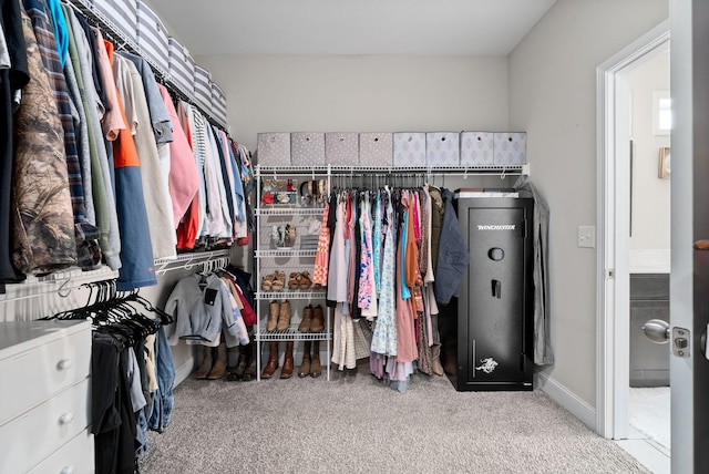 walk in closet featuring light colored carpet