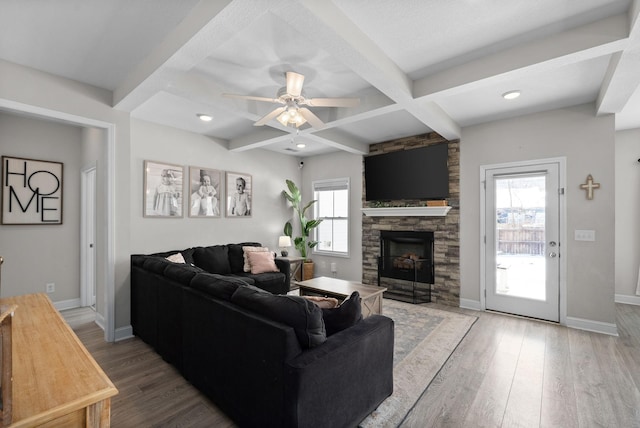 living room with a healthy amount of sunlight, coffered ceiling, and wood finished floors