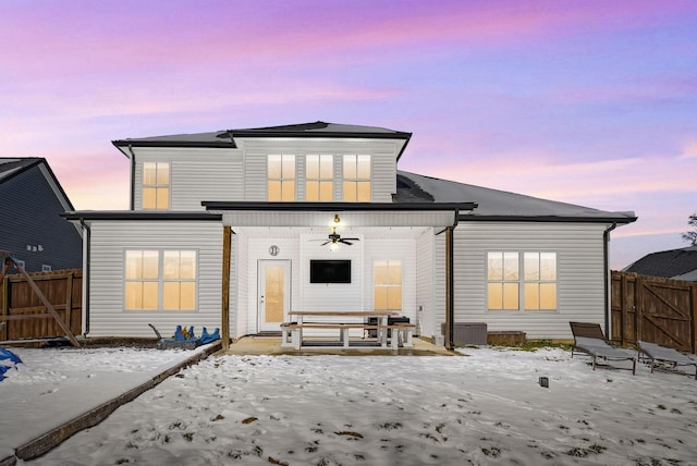 rear view of house with ceiling fan and fence