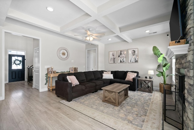 living room with light wood finished floors, baseboards, coffered ceiling, a fireplace, and beam ceiling