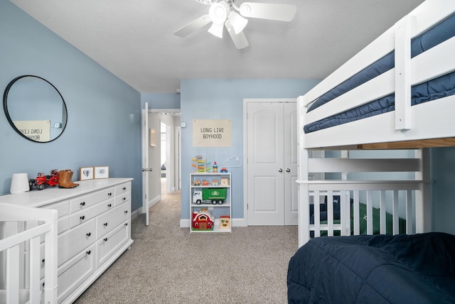 bedroom featuring a ceiling fan, baseboards, a closet, and light colored carpet