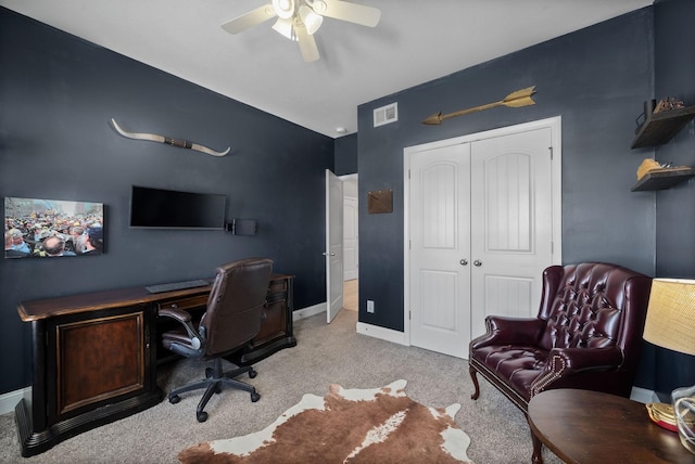 home office with baseboards, visible vents, ceiling fan, and light colored carpet