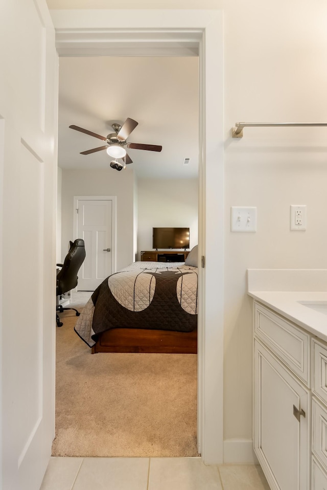 bedroom with light carpet, ceiling fan, and light tile patterned flooring