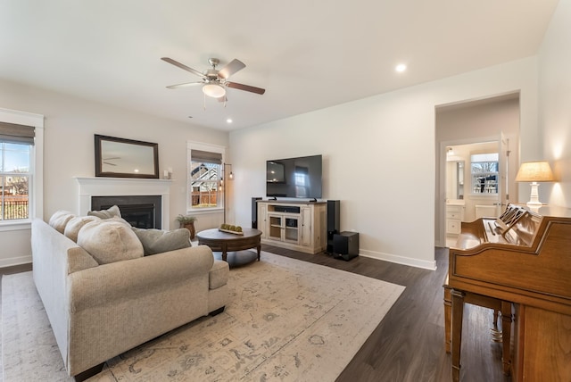 living area with baseboards, a ceiling fan, dark wood-style floors, a fireplace, and recessed lighting