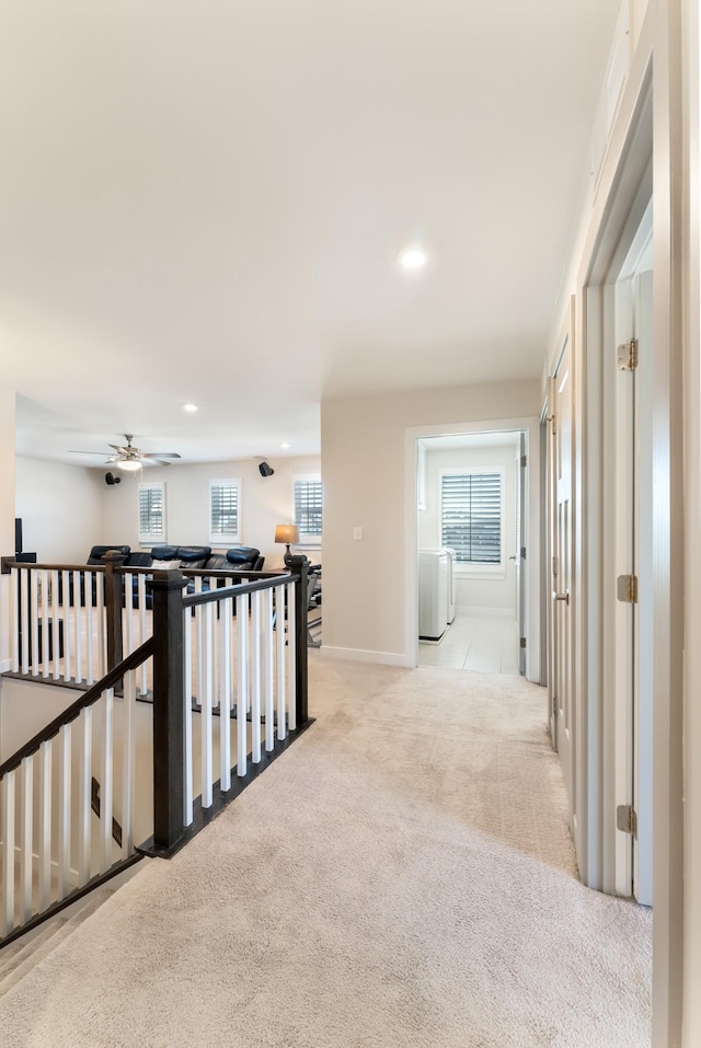 corridor with light carpet, washer / clothes dryer, an upstairs landing, and recessed lighting