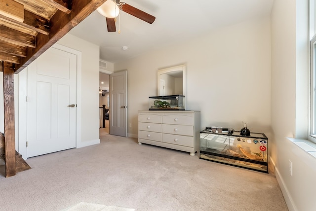 carpeted bedroom featuring a ceiling fan, visible vents, and baseboards