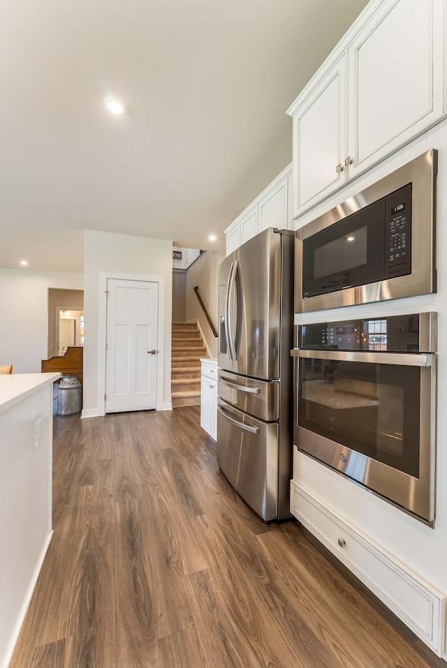 kitchen featuring white cabinets, dark wood-style floors, stainless steel appliances, light countertops, and recessed lighting