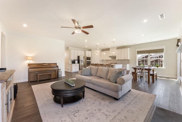 living room featuring dark wood-type flooring, recessed lighting, visible vents, and baseboards