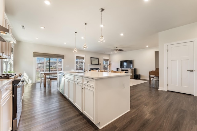 kitchen with stainless steel appliances, light countertops, a sink, and dark wood-style floors