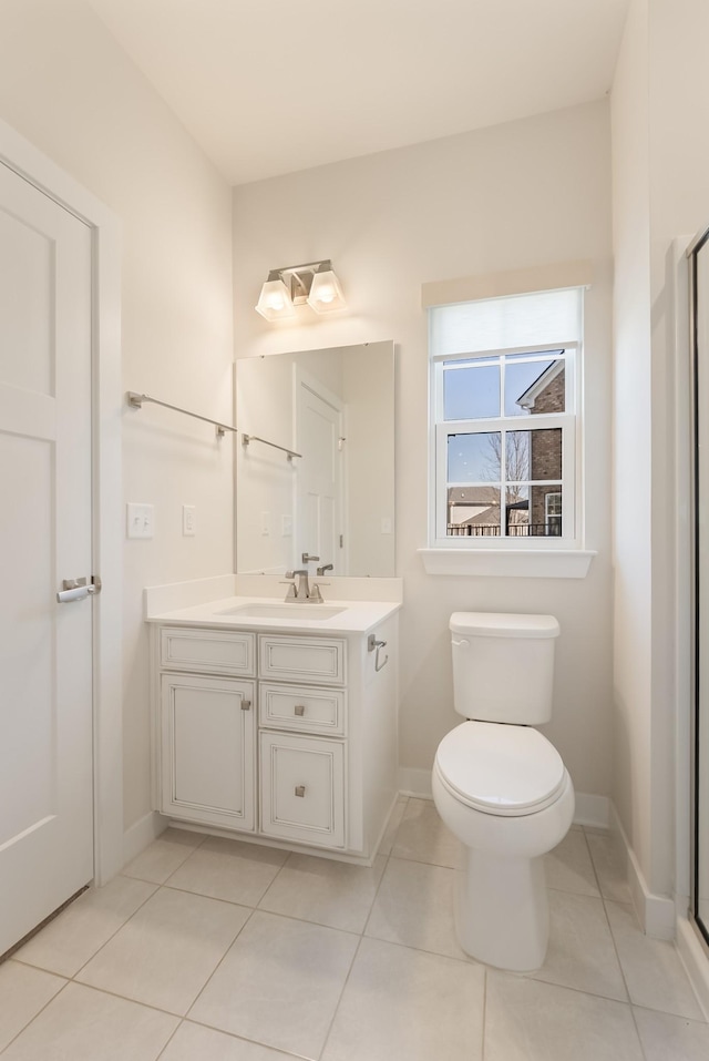 bathroom featuring tile patterned flooring, baseboards, vanity, and toilet