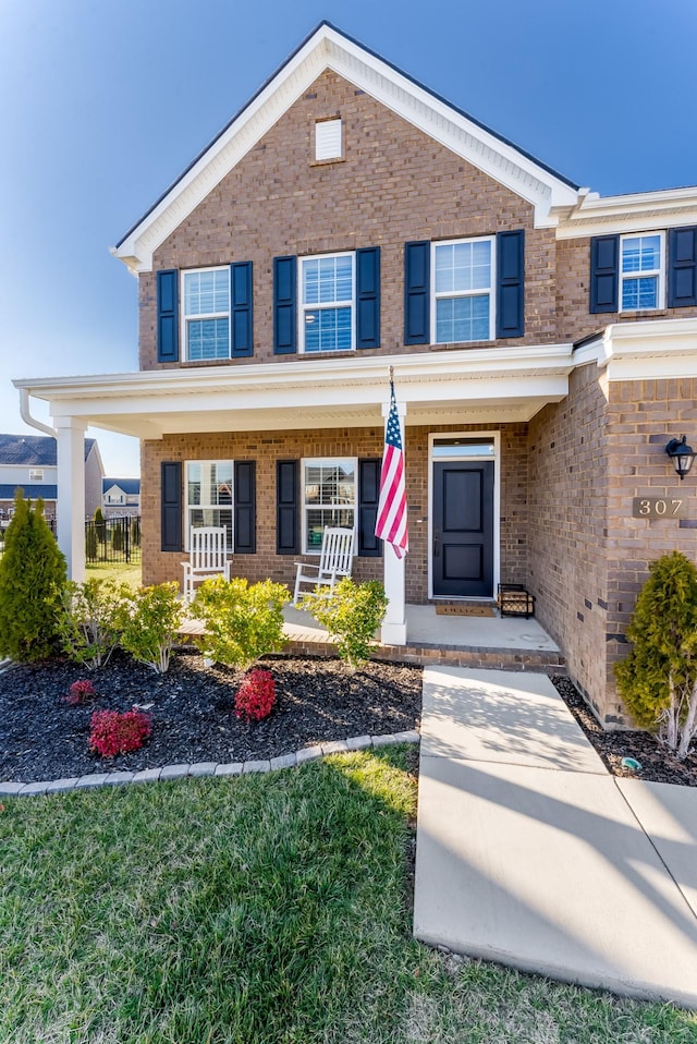 view of front of house with covered porch and brick siding