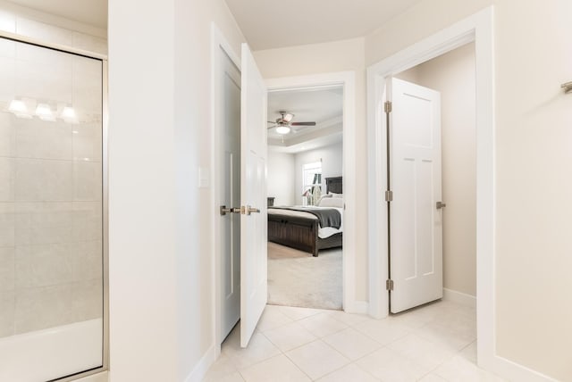 hallway with light tile patterned floors and baseboards