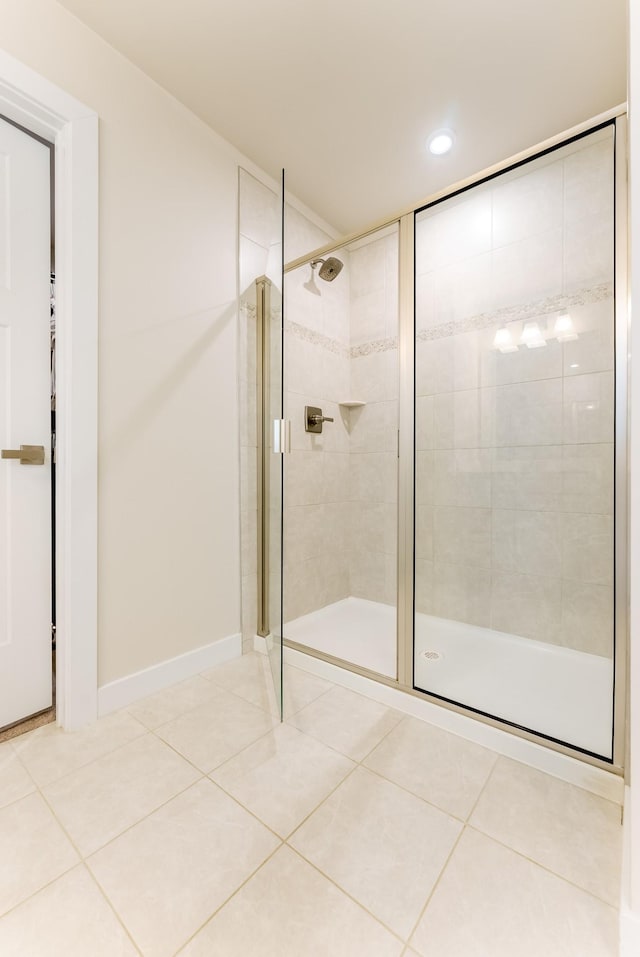 bathroom with a shower stall, baseboards, and tile patterned flooring