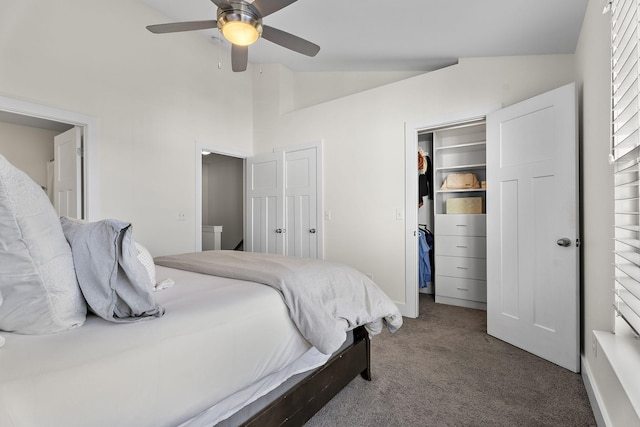 carpeted bedroom with lofted ceiling, a closet, a walk in closet, and a ceiling fan