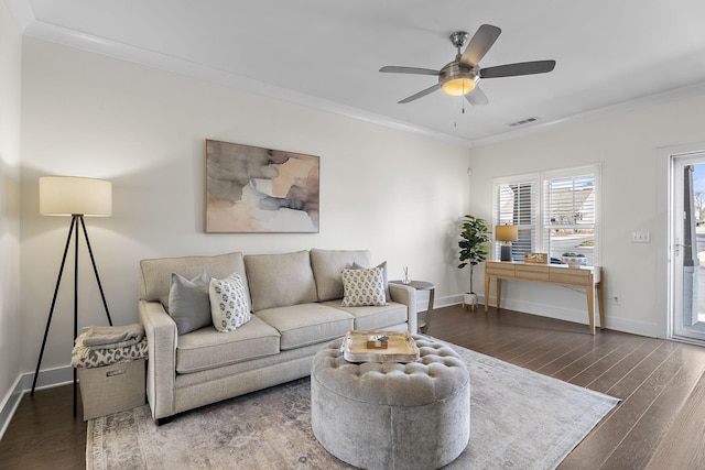 living area featuring baseboards, crown molding, visible vents, and dark wood-type flooring