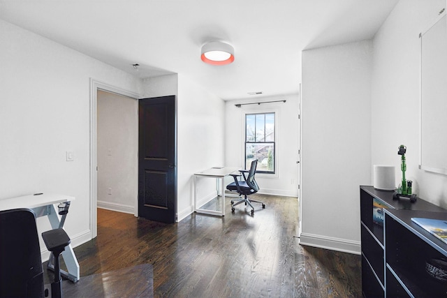 office with dark wood-style flooring, visible vents, and baseboards