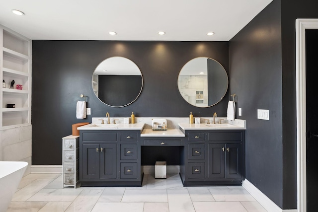 full bathroom featuring double vanity, built in shelves, baseboards, and a sink