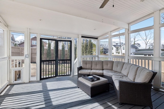 sunroom featuring a ceiling fan and beam ceiling