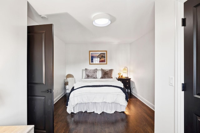 bedroom featuring baseboards and dark wood-type flooring