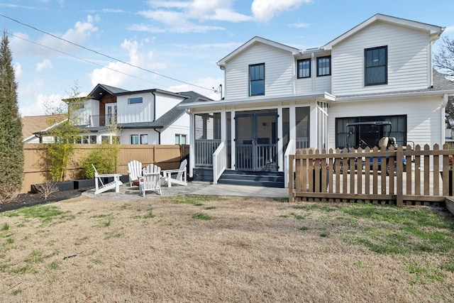 back of property featuring a yard, a sunroom, fence, and a patio