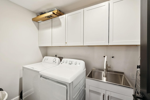 clothes washing area featuring baseboards, cabinet space, independent washer and dryer, and a sink