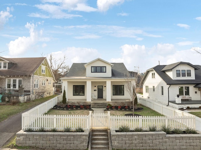 view of front facade featuring a fenced front yard, a residential view, and covered porch