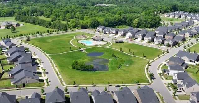 drone / aerial view featuring a forest view and a residential view